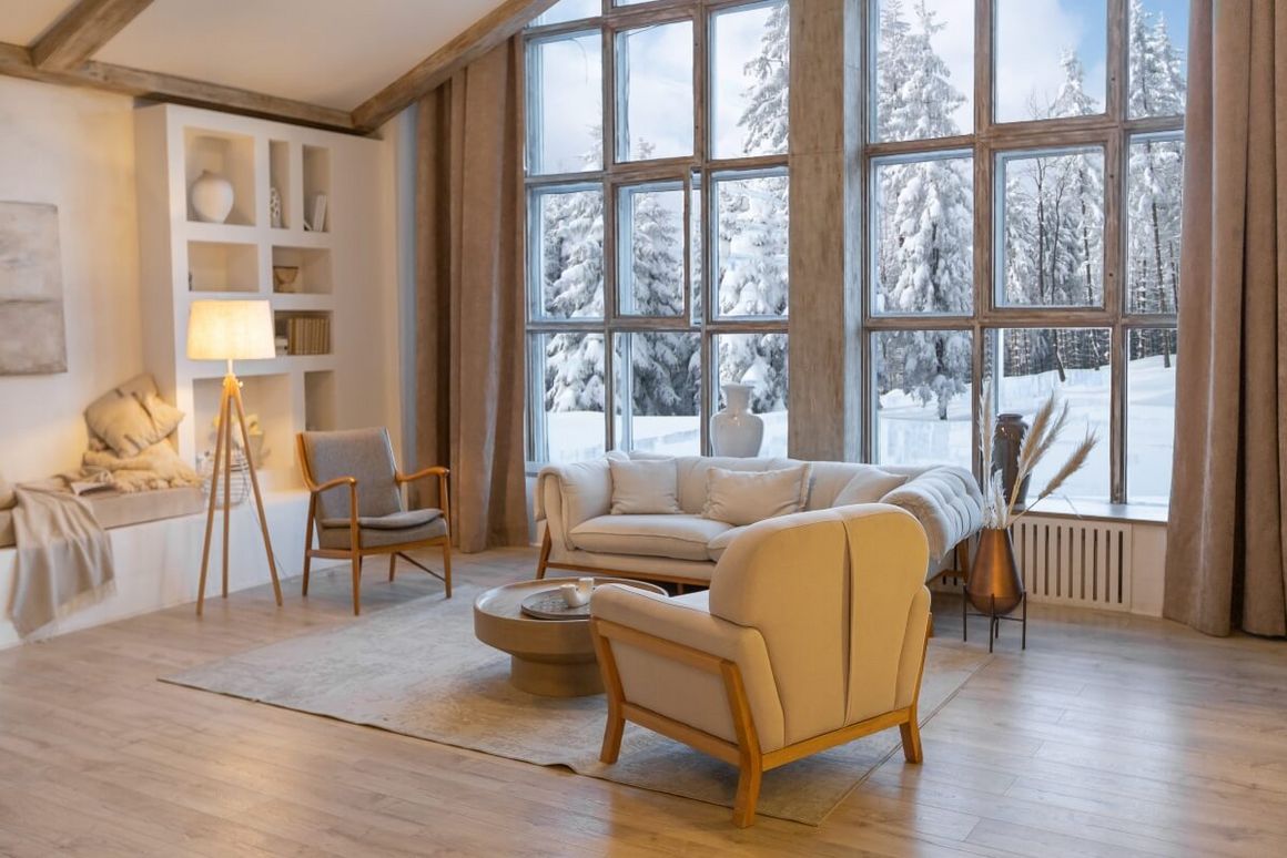 Gemütliches Wohnzimmer mit Blick auf verschneiten Wald